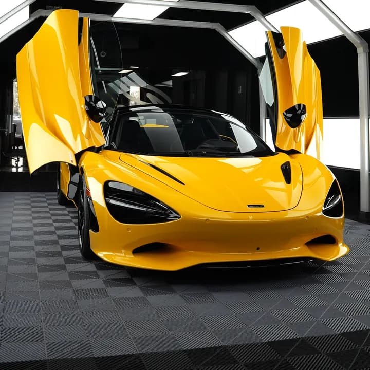 Yellow McLaren 750S with its doors up in a detailing studio