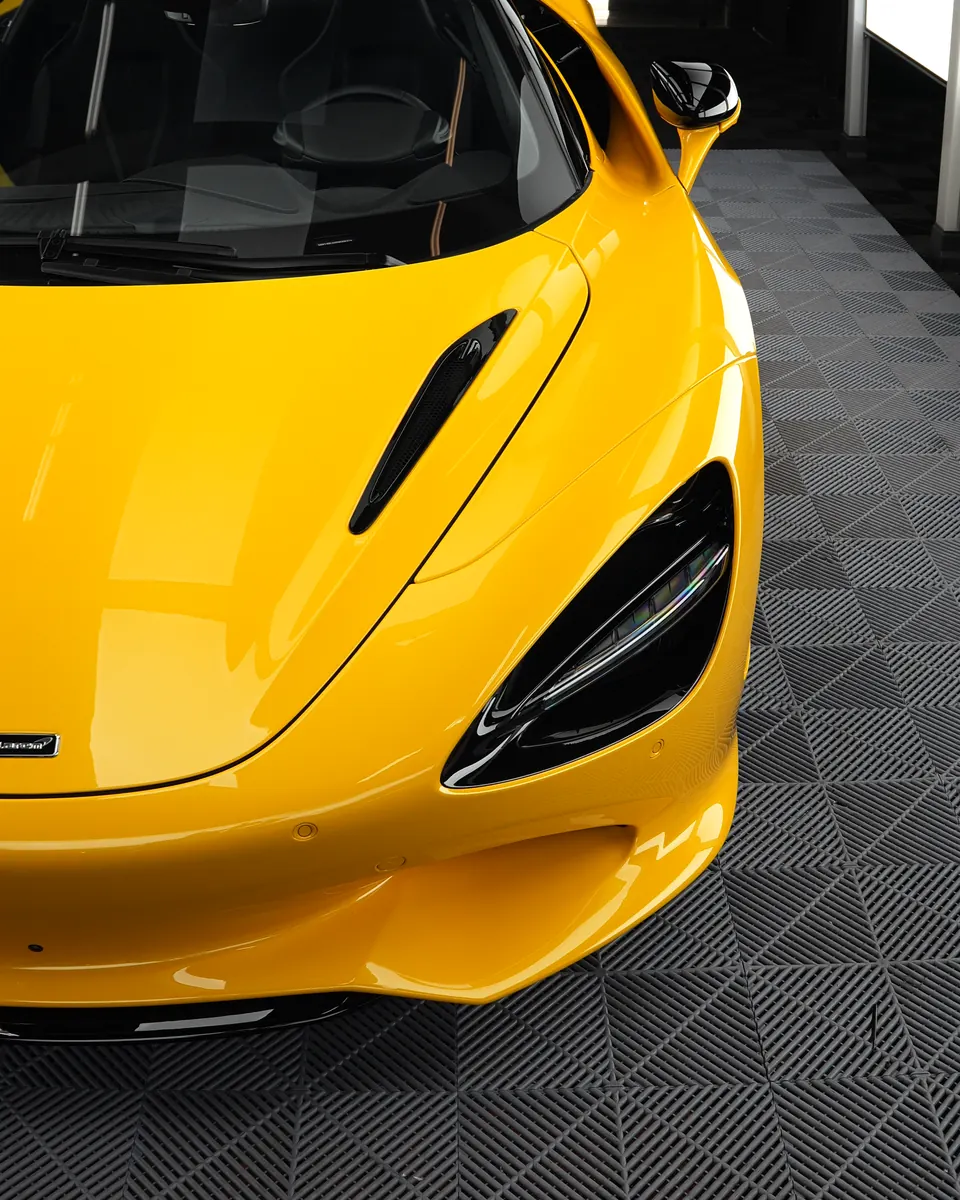 Front of a yellow McLaren 750S in a detailing studio